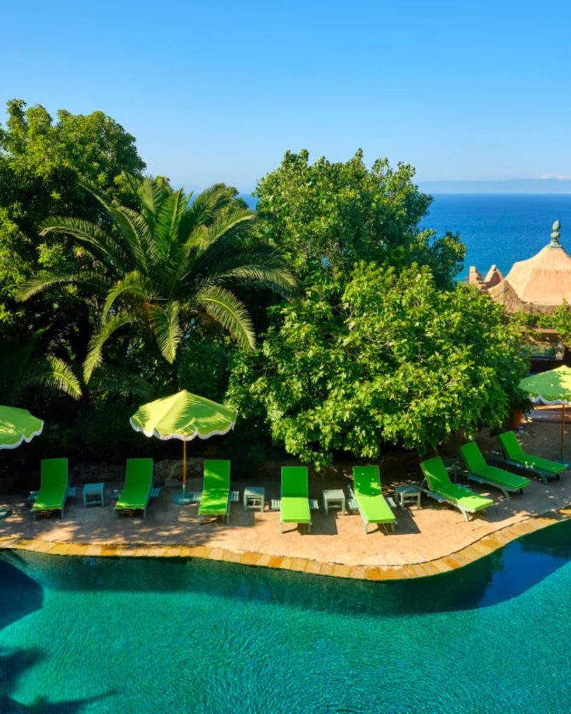 swimming pool with trees and ocean view